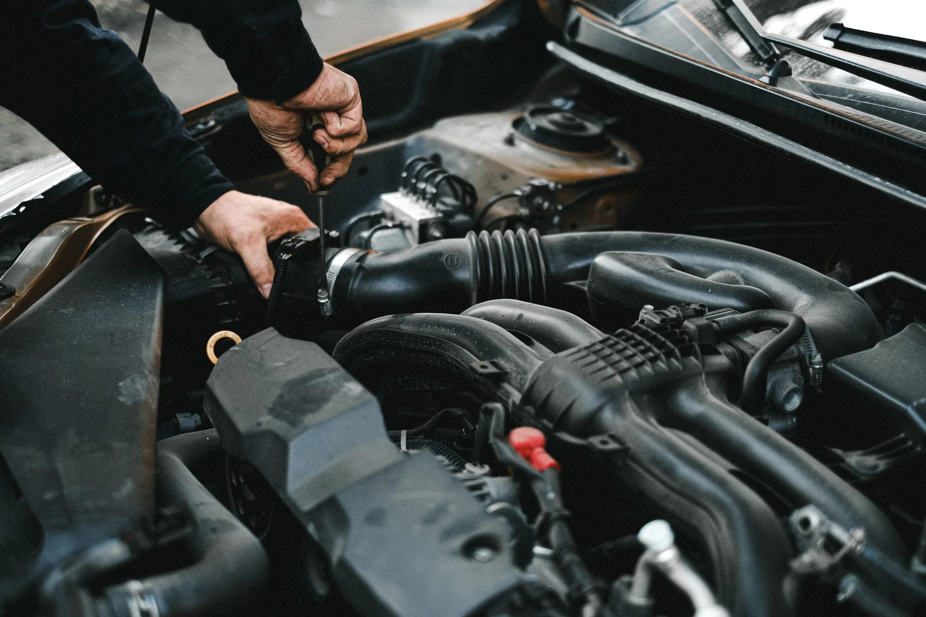 Techniker untersucht den Motorraum eines Fahrzeugs