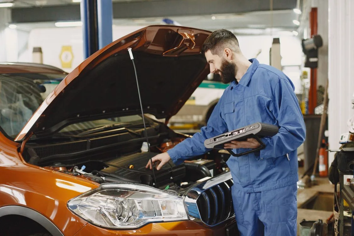 Mechaniker prüft einen Motor bei geöffneter Motorhaube